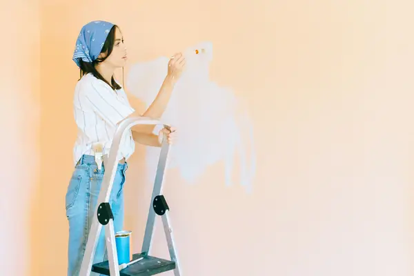 Interior painting in Worcester: painter on a stepladder rolling a wall